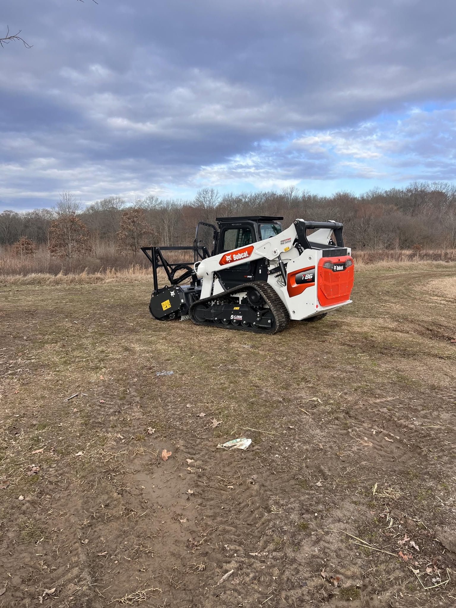 Bobcat skid steer grading a residential driveway
